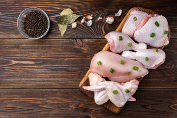 Raw chicken meat on dark wooden background.