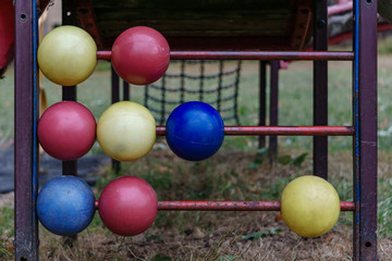 Naklejka premium colorful balls on red metal rods on a kids playground