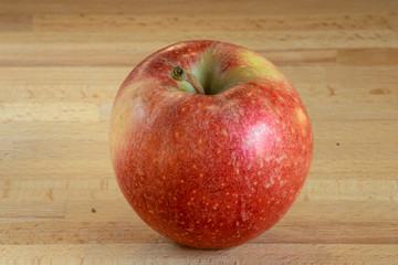 Single isolated red apple on a wooden board