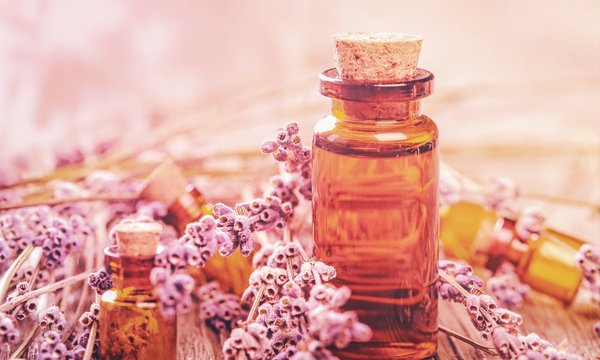 Pile of lavender flowers and a dropper bottle with lavender essence