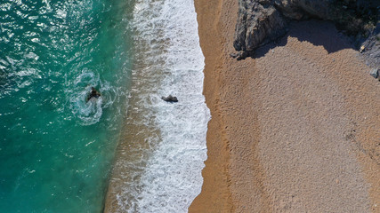Aerial top view photo of tropical paradise deep emerald sea mediterranean sandy beach with strong waves