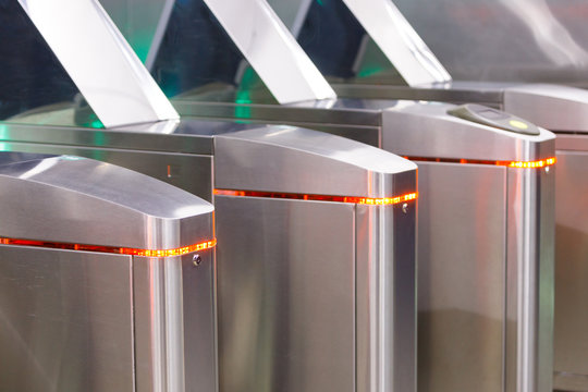 Close up of modern turnstiles for the passage of subway trains transport/ railway station, inside. Entrance in metro with electronic card access. - Powered by Adobe