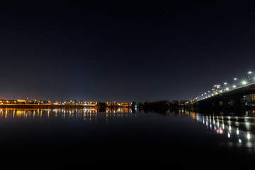 Fototapeta na wymiar dark cityscape with buildings, bridge, lights, river and night sky
