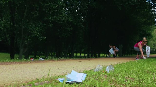 Two girls picking up trash while plogging outdoors