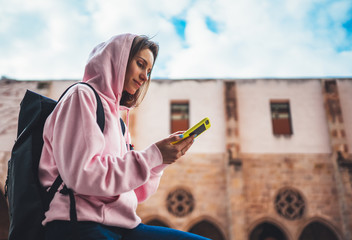 Fototapeta premium girl hold in hands mobile phone, person type message on smartphone, relax tourist travels planning trip in city, hipster enjoy journey in cityscape, lifestyle holiday concept, internet online