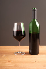 wine glasses with bottle over wooden table