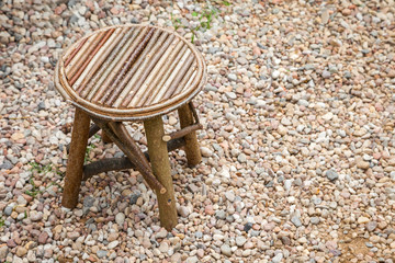 Simple rustic wooden chair. Retro stool on breakstone background.