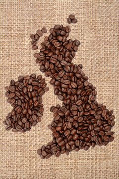 Whole bean coffee. The contour of Great Britain is made of coffee beans on jute burlap