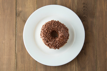 Chocolate donut breakfast or dessert, wooden table. Close up glazed donuts. Sweet food. Pastry.