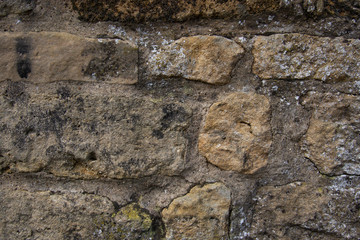 Old beige stone wall background texture.