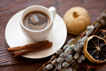 Coffee cup and willow branches, dry lemon, cinnamon.
