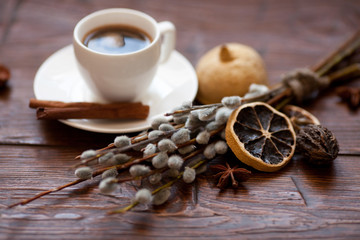 Coffee cup and willow branches, dry lemon, cinnamon.