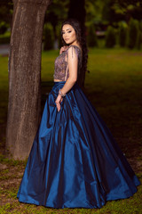 Obraz na płótnie Canvas Beautiful young lady in luxury blue dress for her prom night
