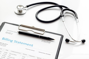 medical treatment bill and phonendoscope on white background