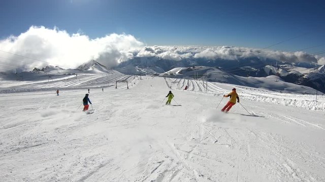 Three Athletes Ski Downhill in a Synchronized Manner in the French Alps