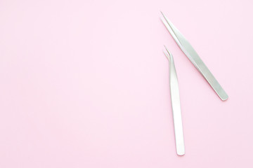 tools for Eyelash Extension Procedure. Two tweezers on pink background. copyspace mockup - Beauty and fashion concept