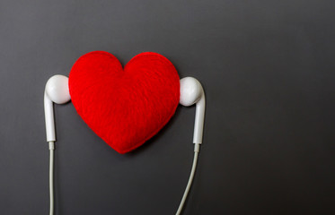 Headphones and red heart on black board background.Listen to your heart concept,Romantic music background. 