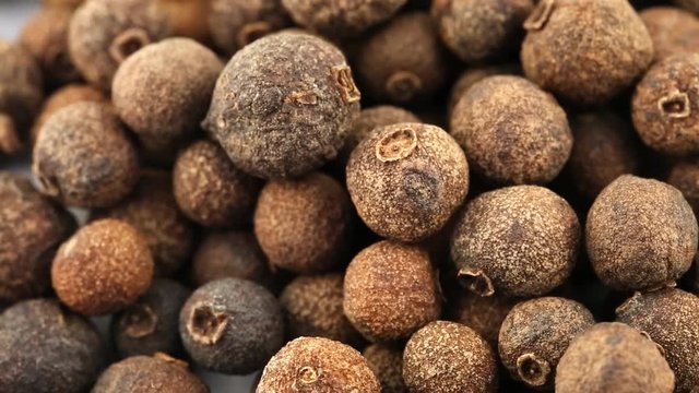 Pile of allspice berries rotating close up macro view - allspice berries are used as seasoning in the kitchen