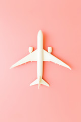 Model plane, airplane on pink pastel color background with copy space.Flat lay design.Travel concept on pink background. top view model plane on pink color background.