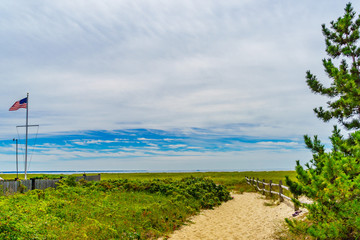 Fototapeta na wymiar Empty pathway with fence to the beach on a clear summer day in Provincetown, Cape Cod, Massachusetts