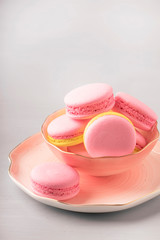 Pink yellow macaroons cakes on gray blue table background, place for text, trendy minimalism style, selective focus