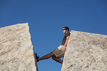 A young man resting on granite rocks after bouldering on a summer afternoon.
