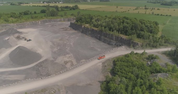 aerial dumptruck drives into rock quarry for gravel
