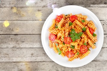 Spaghetti pasta with tomatoes and parsley on  table.