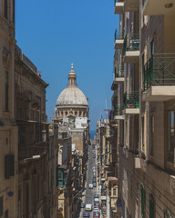 Streets and buildings in downtown Valletta, Malta, with dome of Basilica of Our Lady of Mount Carmel
