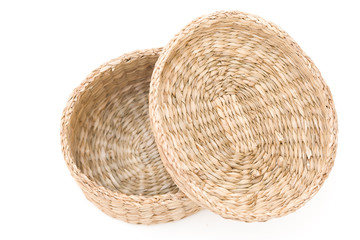 Small, empty,  wicker basket with top laying across the top on a white background