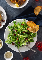 Vegetarian dinner table with bowl green salad vegetable cutlets