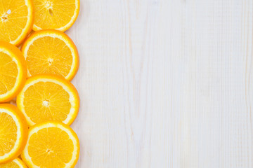 Frame with orange on wooden background. Empty space for text