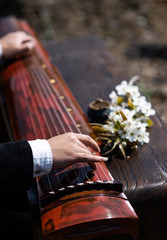 The man is playing the Guqin