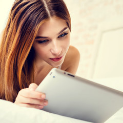 Young woman using tablet pc, at home