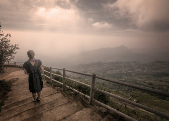 The image of an unknown woman standing back on a high slope walkway, an ancient portrait of a black and white tone standing