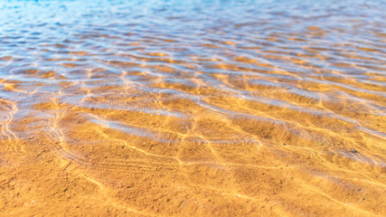 Clear smooth wave beach with sand texture background.