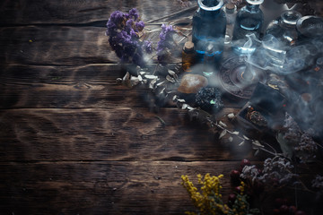 Various dried herbs and bottles on a brown wooden table. Herbal medicine, alternative medicine...