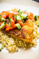 Prepared tilapia fish fillet served with salad. Selective focus. Shallow depth of field. 