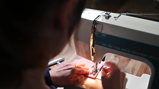 &Uuml;ber Schulter Videoaufnahme einer Frau, die ein St&uuml;ck Stoff mit einer N&auml;hmaschine n&auml;ht.