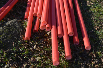 Stack red plastic electricity cable protection pipes