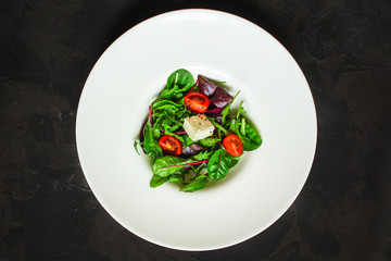 Healthy salad, leaves salad mix in a white plate and cheese (green, juicy snack). food background - Image
