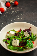 Healthy salad, leaves salad mix in a white plate and cheese (green, juicy snack). food background - Image