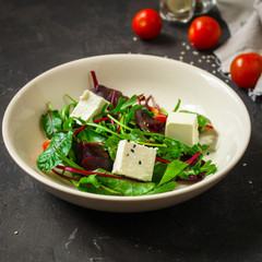 Healthy salad, leaves salad mix in a white plate and cheese (green, juicy snack). food background - Image