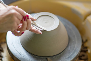 Artist make pot of mug at pottery wheel with hands