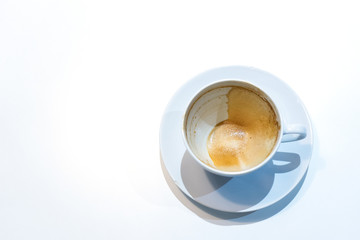 Top view of an empty coffee cup with coffee stains at the bottom of the cup after finish drinking. Dirty cup on on white background.