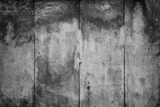 Close-up of a weathered and aged concrete wall with vignette in black and white. Full frame texture background of the original Berlin Wall.