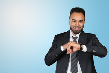 Handsome African American young man  looking at watch. Copy space