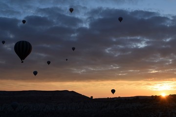 Sunrise and balloons. Beautiful background of the balloon and the sunset.Cappadocia. Turkey. Göreme. Nevşehir. Türkiye. 8. 04. 2019. Balloons flying over the rocky landscape in Cappadocia Turkey. View