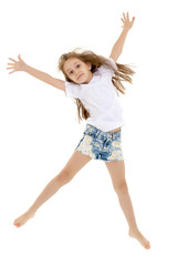 A little girl in a pure white t-shirt is jumping. The concept of