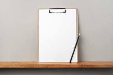 front view of A4 paper with clipboard on bookshelf